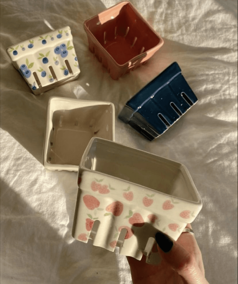 Five finished berry baskets — strawberries, blueberries, terracotta, and deep blue