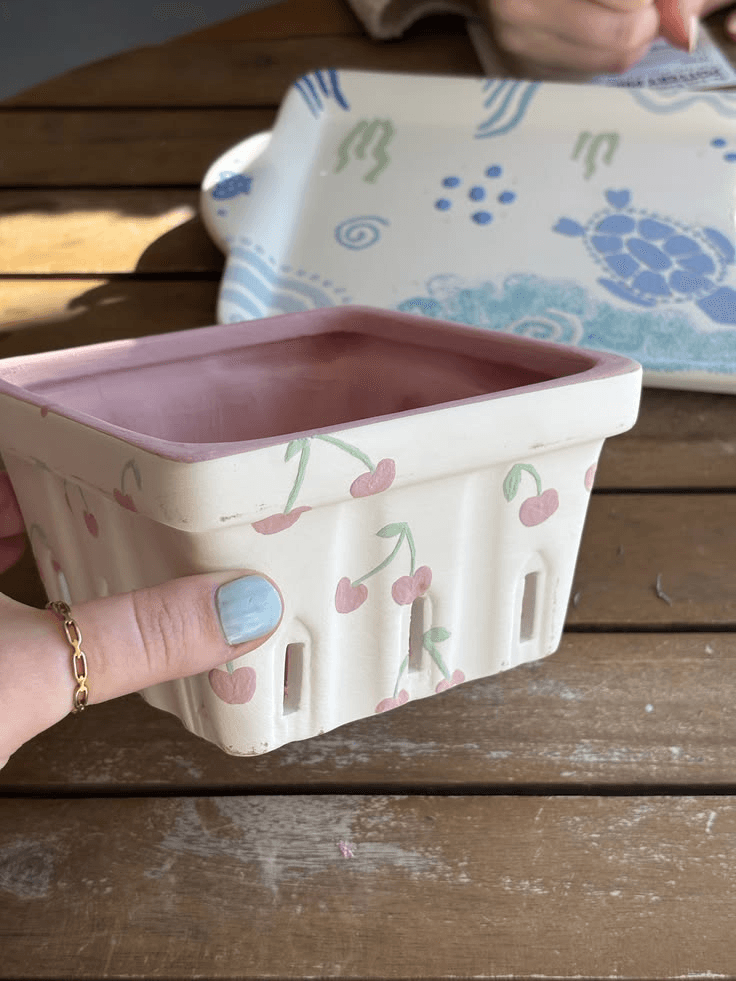 A pink berry basket hand-painted with cherries
