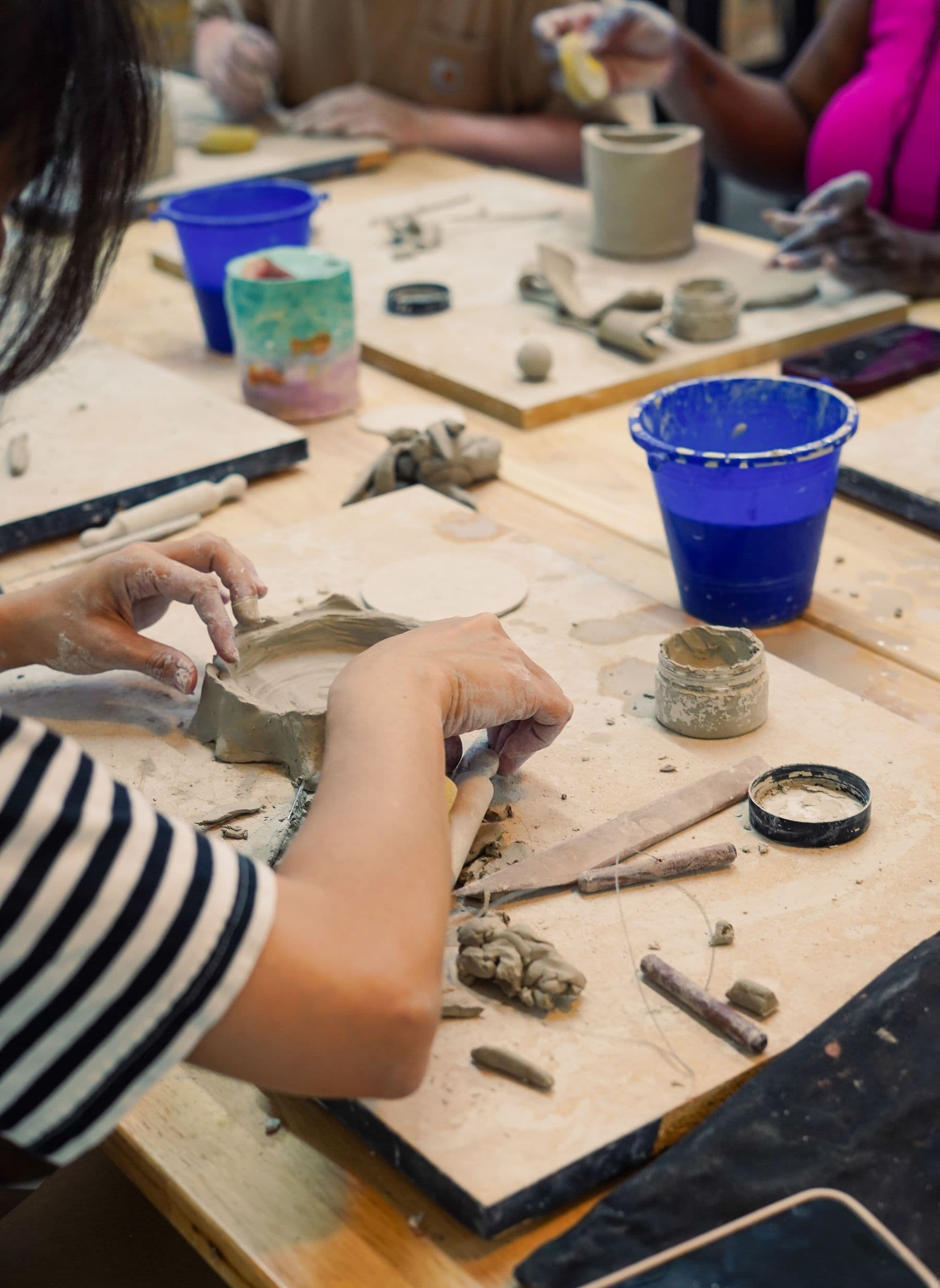 Handbuilding pottery at a shared studio table