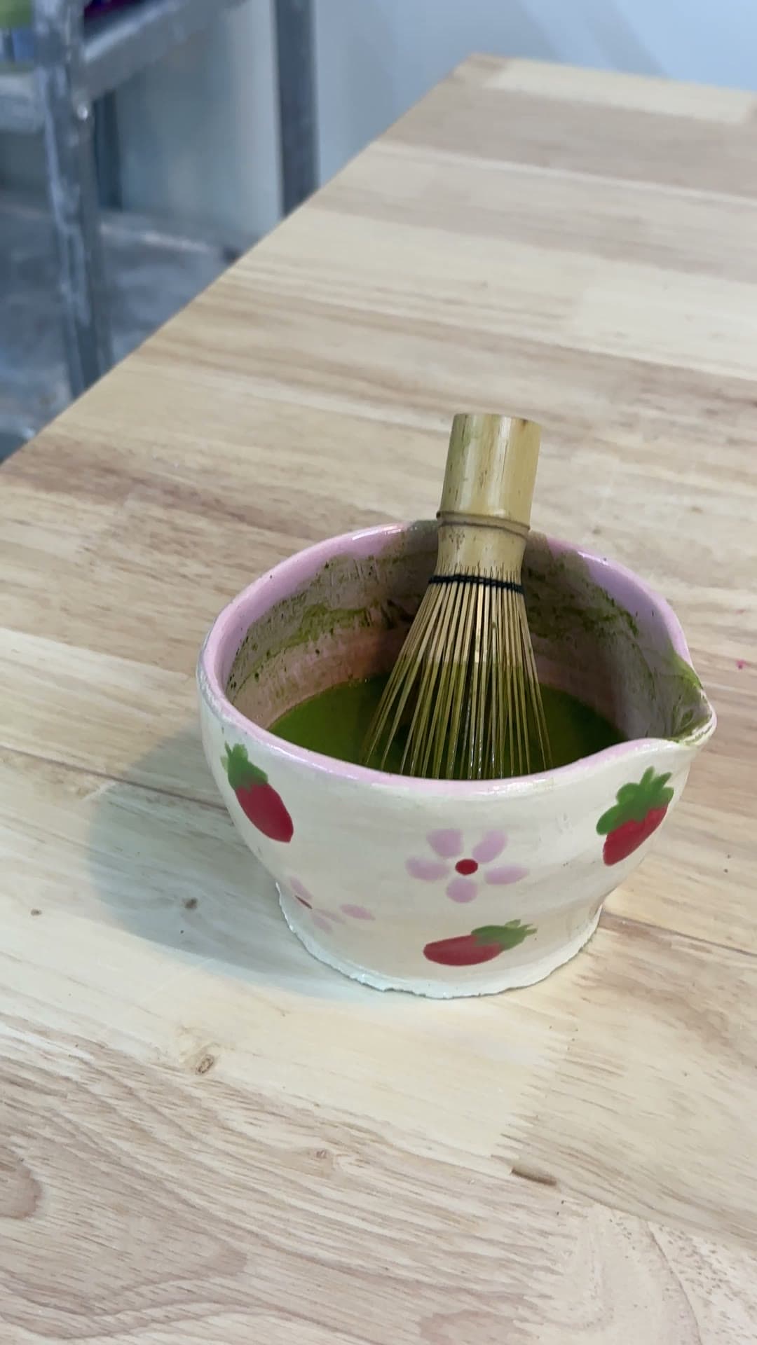 Handmade strawberry matcha bowl with bamboo whisk