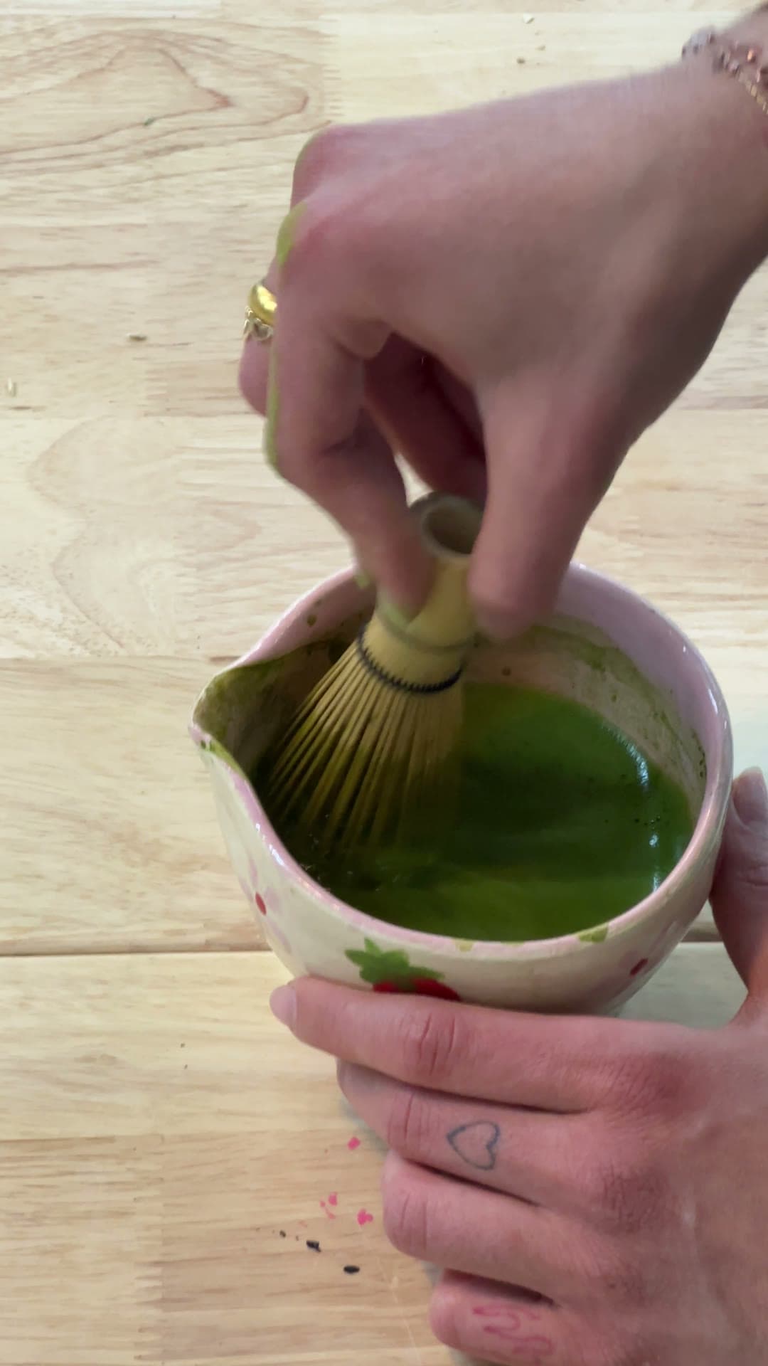 Whisking fresh matcha in a handmade ceramic bowl