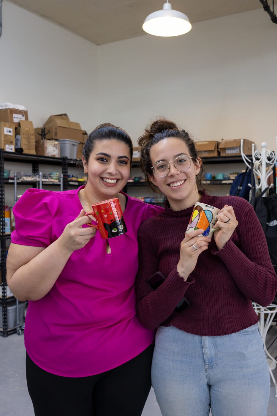 Two guests showing off their finished mugs